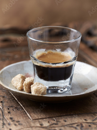 Coffee in glass cup on rustic wooden background. Close up. 