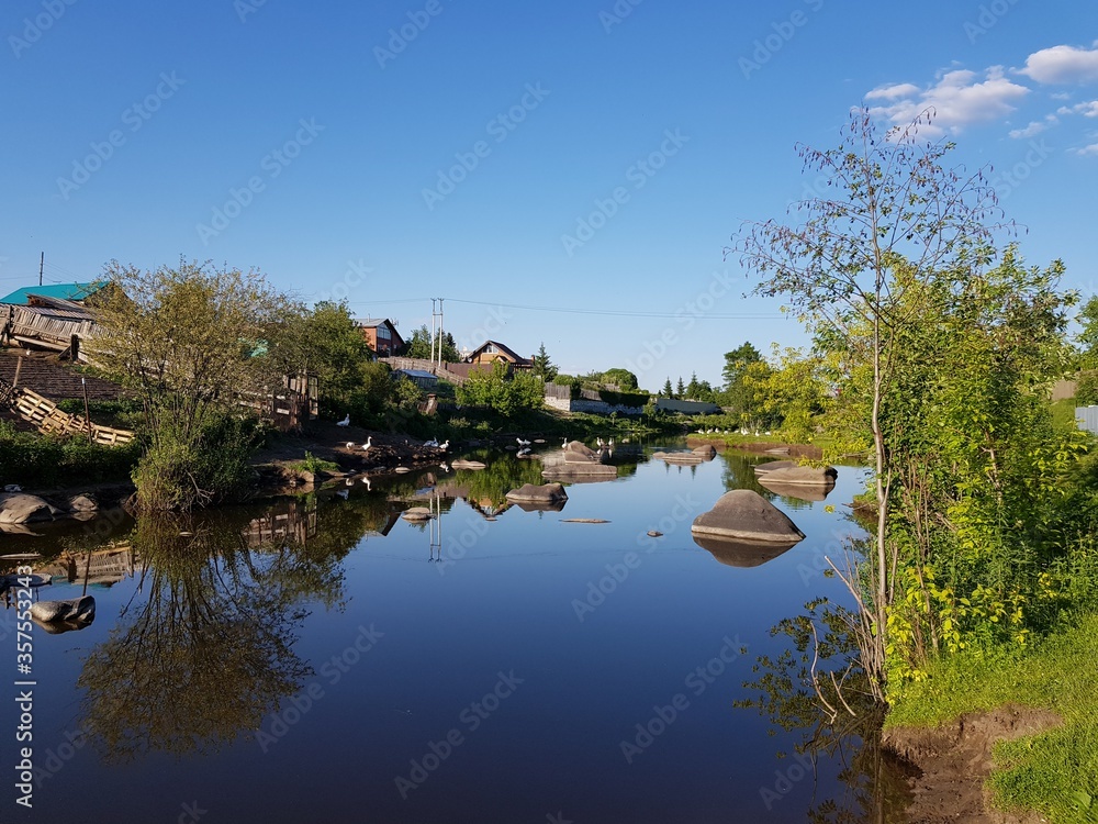 The village is reflected in the river