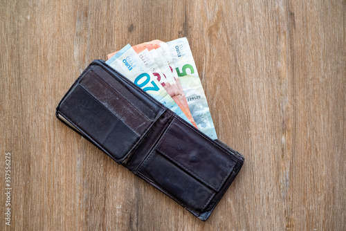 Obraz na płótnie Old shabby wallet with euro money on a wooden background w salonie