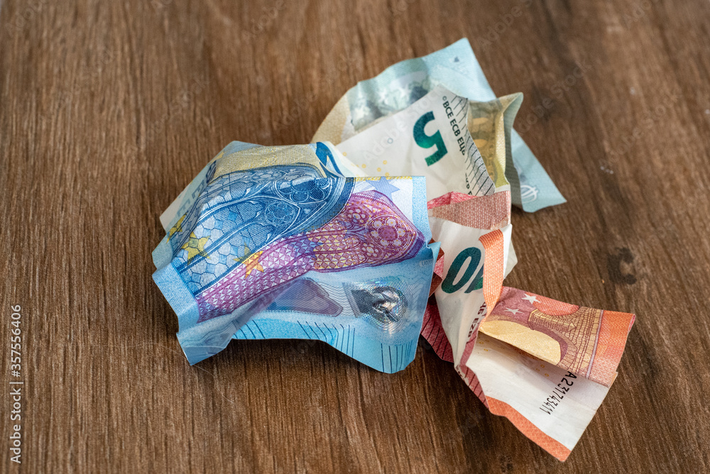 Crumpled euro money on a wooden background. Money in the period of inflation.