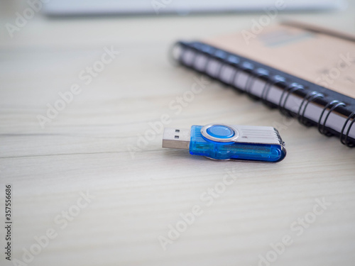 selective focus usb flash drive on table blurred notebook background.