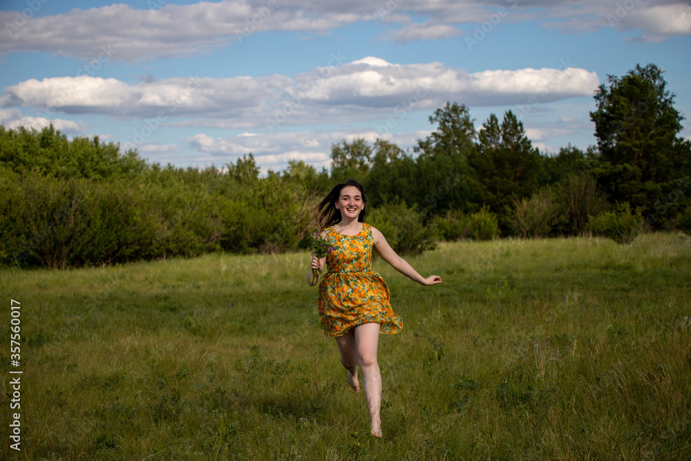 Young smiling girl with her hair down running barefoot on the grass Young smiling girl with her hair down running barefoot on the grass