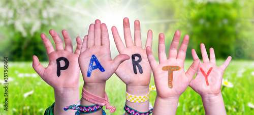 Children Hands Building Colorful English Word Party. Sunny Green Grass Meadow As Background