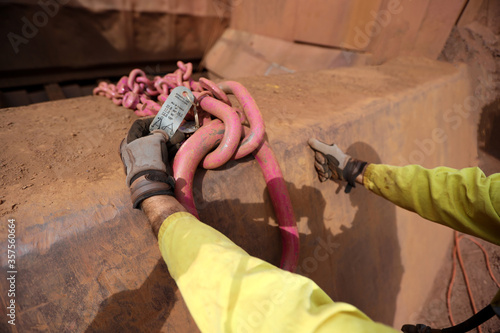 Obraz na plátně Trained crane rigger hand wearing a glove inspecting  crane lifting tag on the c