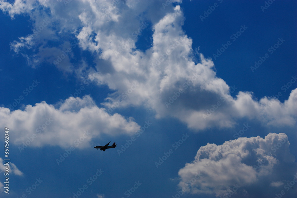 夏の青空と綺麗な雲と飛んでいる飛行機