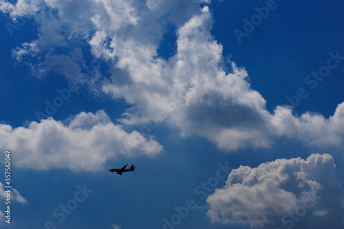 夏の青空と綺麗な雲と飛んでいる飛行機
