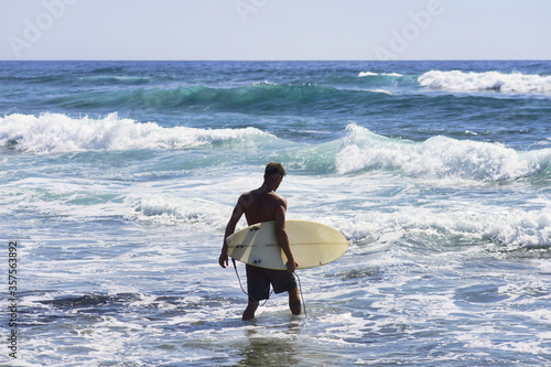 surfer goes to ride the waves