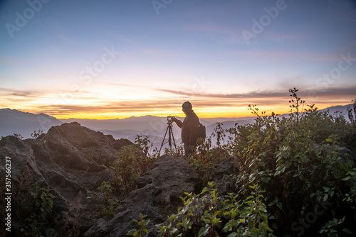 A Photographer in action during sunrise in the mountains © Ravi