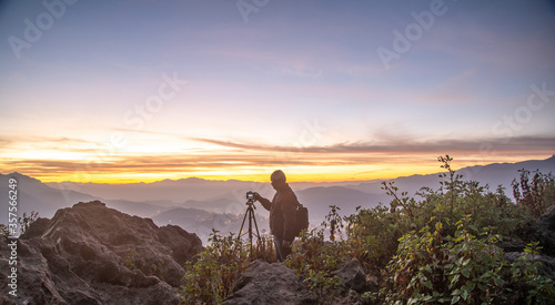 A Photographer in action during sunrise in the mountains