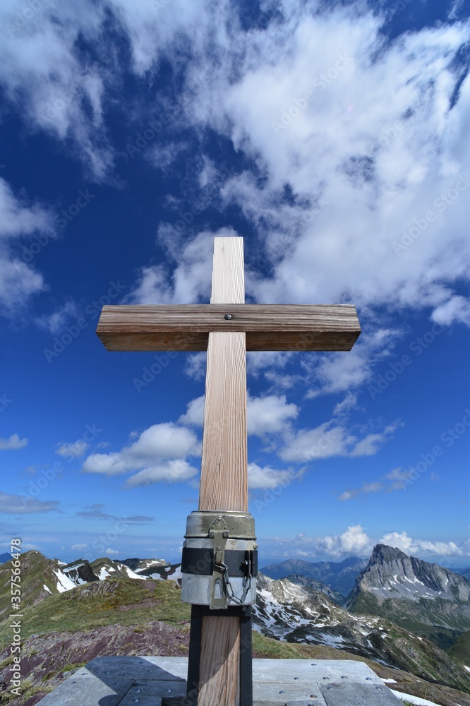 Wooden summit cross in the Glarus Alps on a sunny day in Switzerland