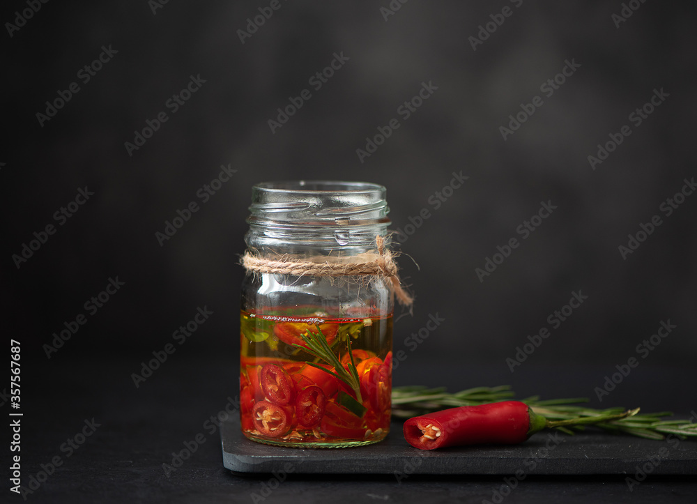 red and green chili peppers in a glass jar with olive oil red and green chili peppers in a glass jar with olive oil