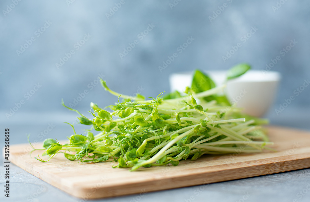 fresh pea microgreens on a wooden board for salad fresh pea microgreens on a wooden board for salad