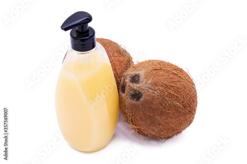 bottle of body coconut oil and isolated coconuts photo