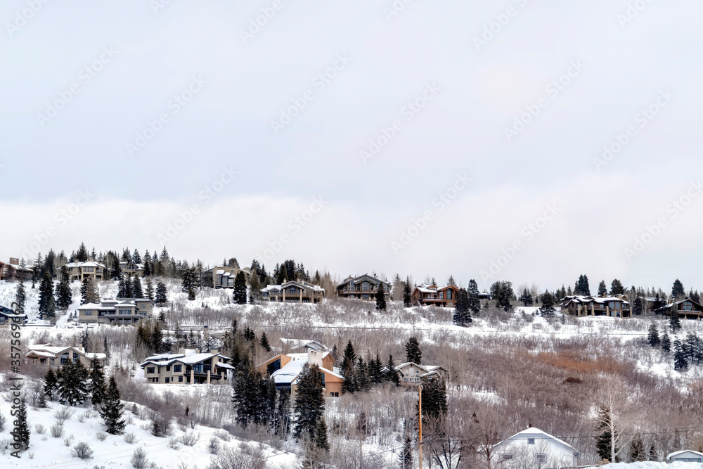 Neighborhood homes sitting on snow covered mountain slope in Park City Utah