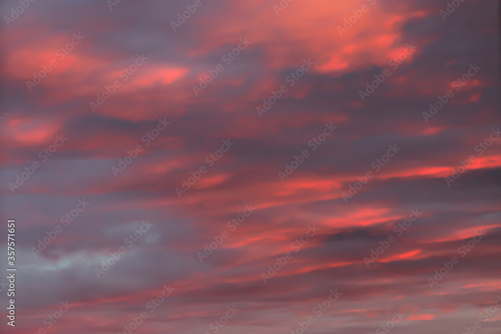 Colorful pink orange sunset sky with thick clouds