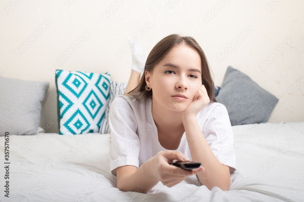 Lifestyle girl watching TV at home, lying on the bed Lifestyle girl watching TV at home, lying on the bed