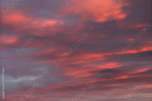 Colorful pink orange sunset sky with thick clouds © yta