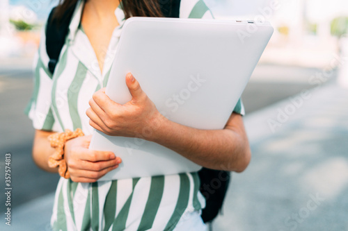 Close up of a businesswoman and freelancer picking up a white laptop. Freelance concept.