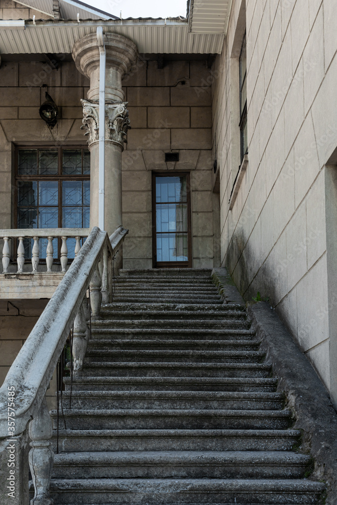 An old building with columns and stucco. Wide staircases lead to the second floor. Strict geometry. Summer. High quality photo An old building with columns and stucco. Wide staircases lead to the second floor. Strict geometry. Summer. High quality photo