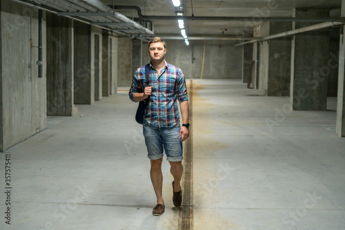 Attractive young man walking through a basement