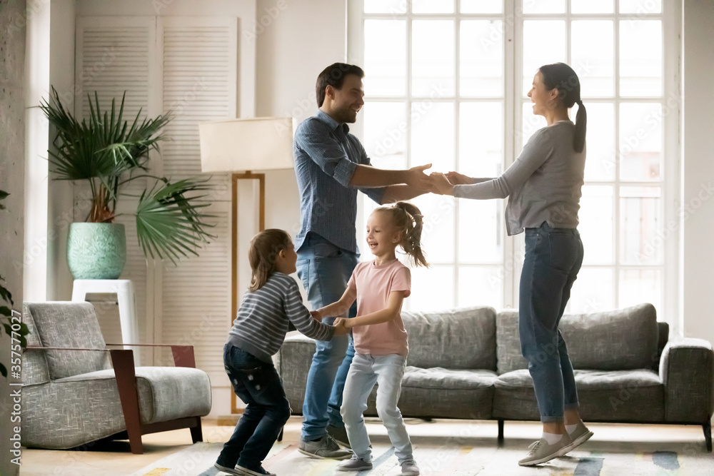 Φωτογραφία Happy young woman with man and adorable little daughter and son holding hands, d