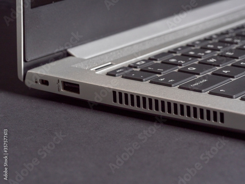 Wallpaper Mural part of the open laptop made of aluminum on a gray background. Side view, copy space. Torontodigital.ca