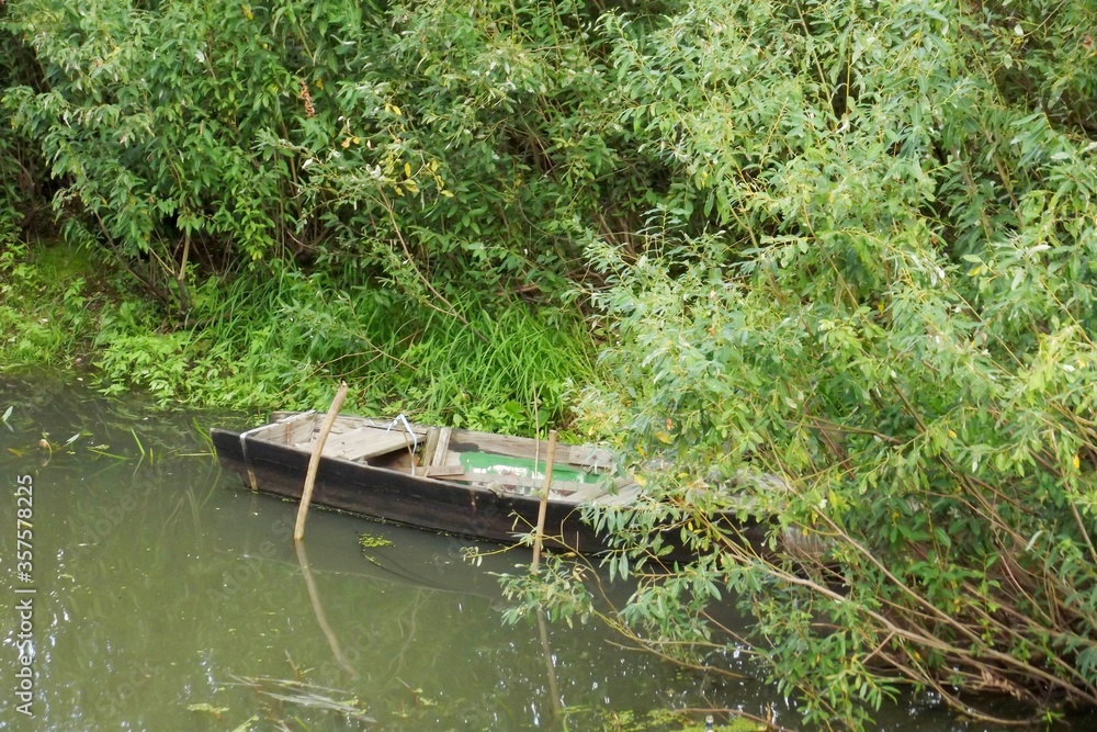 An old wooden boat is located on a forest lake