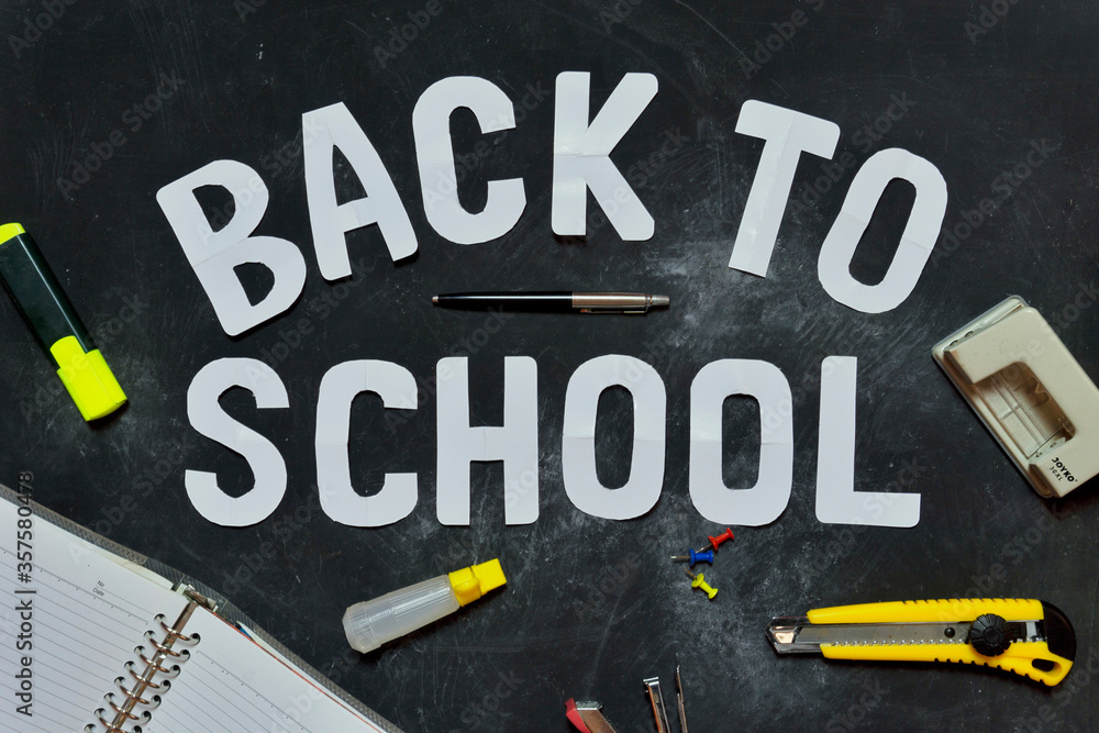 Cutouts of the greeting words Back to school on the blackboard and some stationery Cutouts of the greeting words Back to school on the blackboard and some stationery