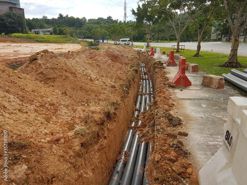 Fotografie SEREMBAN, MALAYSIA -AUGUST 01, 2019: Underground utility and services pipe laid by workers in the trenches at the construction site