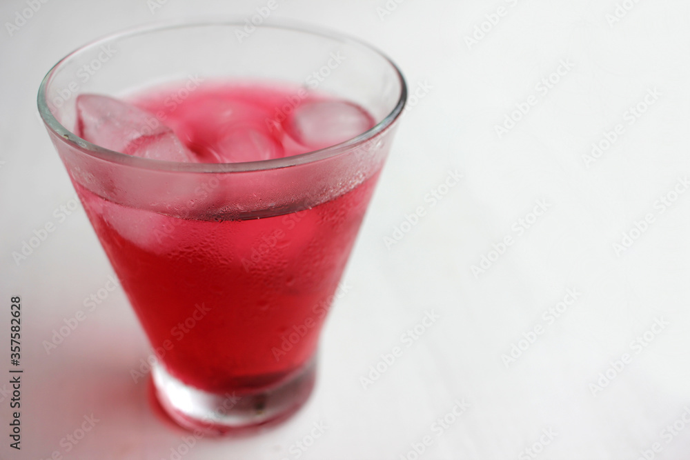 Cold hibiscus tea with ice cubes in the glass. Refreshing non-alcoholic summer drink Cold hibiscus tea with ice cubes in the glass. Refreshing non-alcoholic summer drink