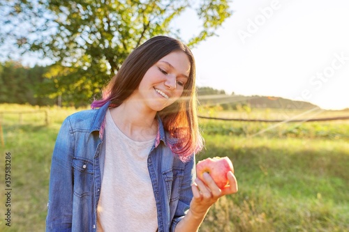 Portrait of happy beautiful teenage girl 15  16 years old with red apple