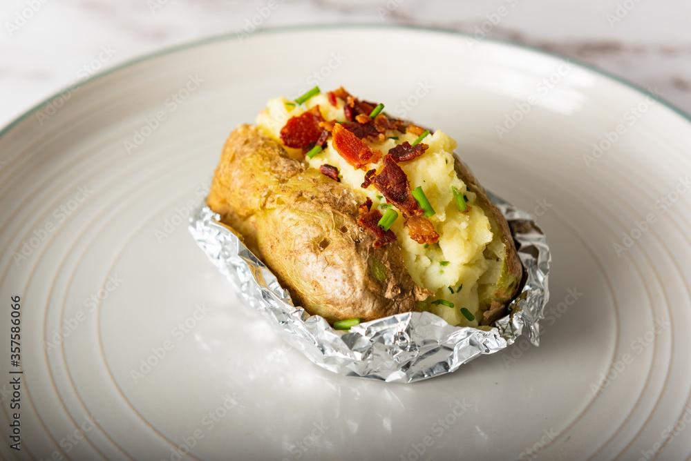 Home cooking jacket potato, filled with sour cream, bacons and chives
