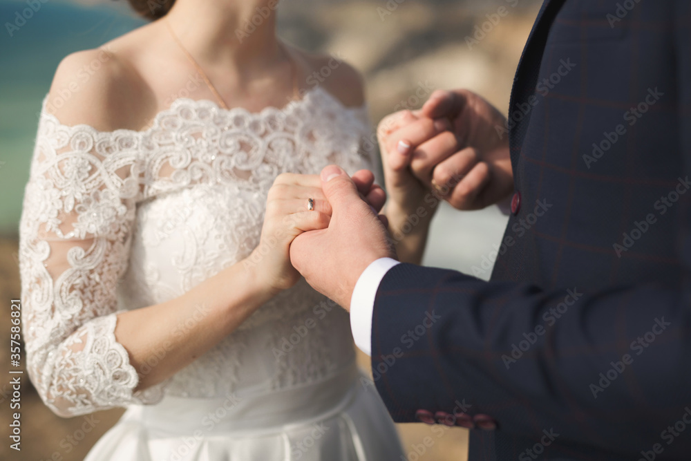Bride and groom hold hands during the wedding ceremony