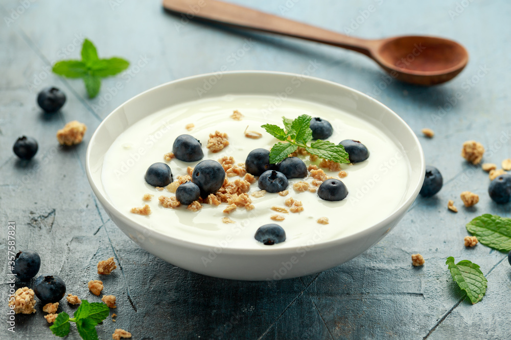 Greek yogurt with granola and blueberries in white bowl. Healthy breakfast food or snack Greek yogurt with granola and blueberries in white bowl. Healthy breakfast food or snack