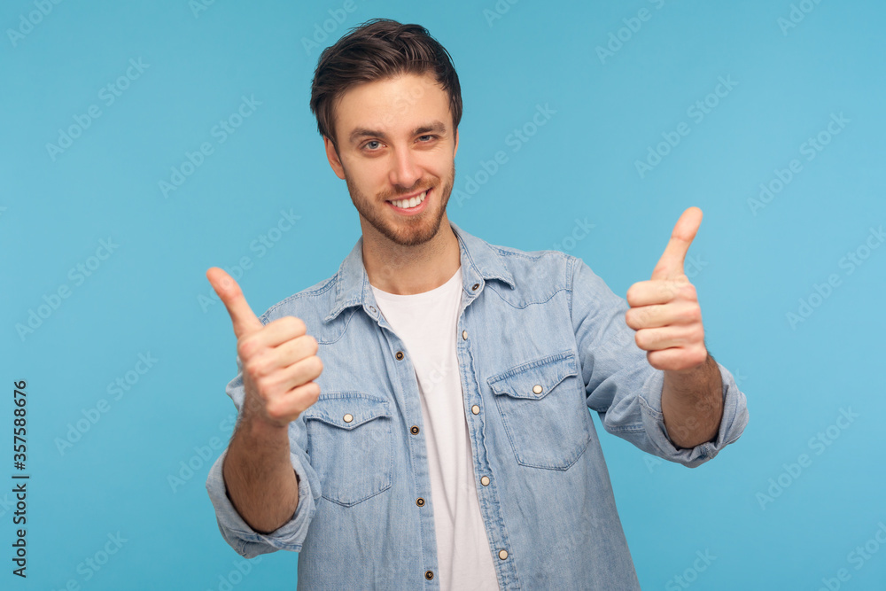 Well done, excellent job! Portrait of smiling satisfied man in worker denim shirt standing with thumbs up, like gesture, demonstrating approval and agree with suggestion. indoor studio shot isolated Well done, excellent job! Portrait of smiling satisfied man in worker denim shirt standing with thumbs up, like gesture, demonstrating approval and agree with suggestion. indoor studio shot isolated