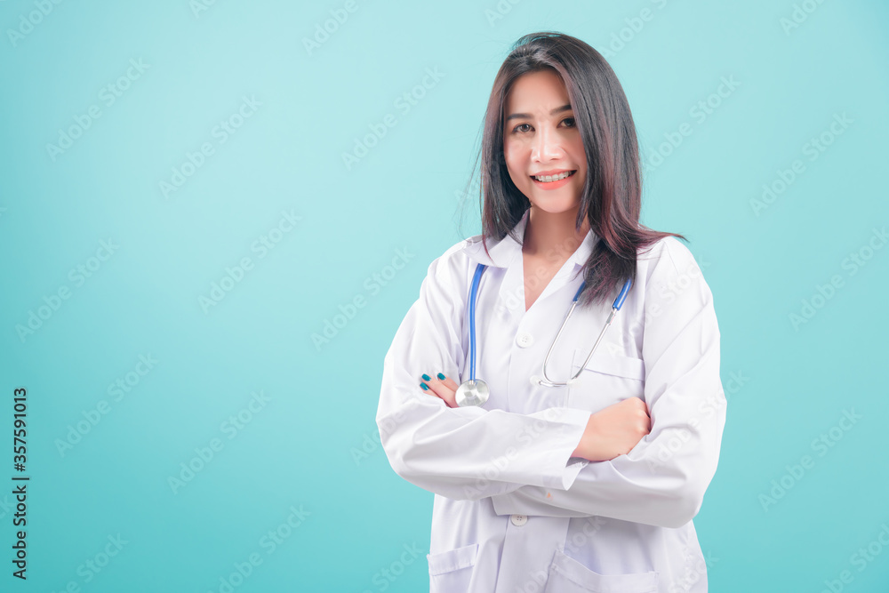 Asian doctor, happy beautiful young woman in uniform standing arms crossed against, smiling with stethoscope on blue background with copy space for text Medical health care staff service concept Asian doctor, happy beautiful young woman in uniform standing arms crossed against, smiling with stethoscope on blue background with copy space for text Medical health care staff service concept