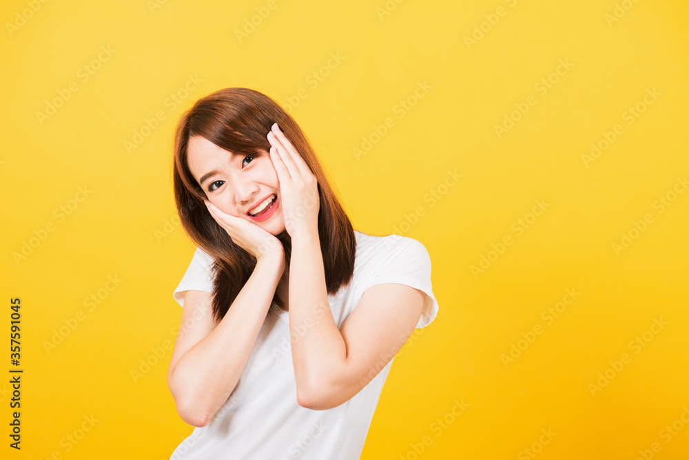 Asian happy portrait beautiful cute young woman teen stand surprised excited celebrating open mouth gesturing palms on face looking to camera isolated, studio shot yellow background with copy space Asian happy portrait beautiful cute young woman teen stand surprised excited celebrating open mouth gesturing palms on face looking to camera isolated, studio shot yellow background with copy space