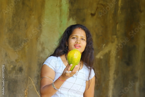 beautiful young indian girl holding papaya