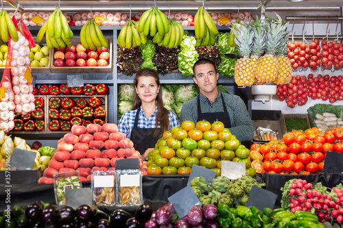 Vegetable shop sellers posing behind the counter photo