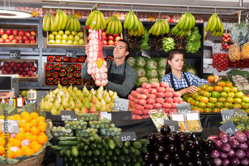 Two sellers laying out vegetables photo