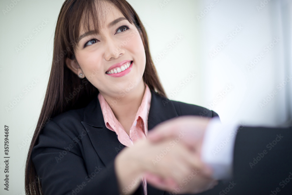 Beautiful Asian business woman wears a black suit and hand in hand with a partner and smile confidently. Asian business women, Executive new generation, Business owners, and office staff. Concept Beautiful Asian business woman wears a black suit and hand in hand with a partner and smile confidently. Asian business women, Executive new generation, Business owners, and office staff. Concept