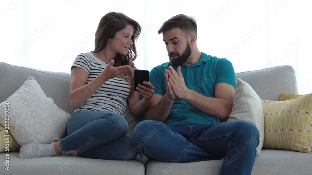 Young couple arguing about texting messages on his cell phone and guy pretend that he dont know what his jealous girl talking about Young couple arguing about texting messages on his cell phone and guy pretend that he dont know what his jealous girl talking about