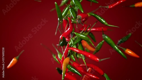 Super Slow Motion Shot of Mixed Chilli Side Colision on Dark Red Background at 1000fps. photo