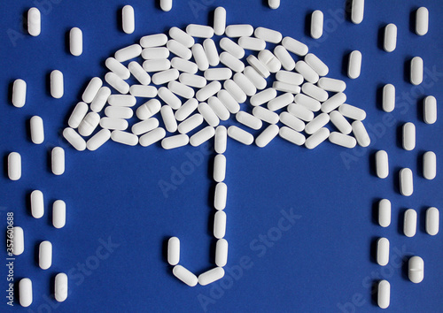 White pills on blue background forming an umbrella shape