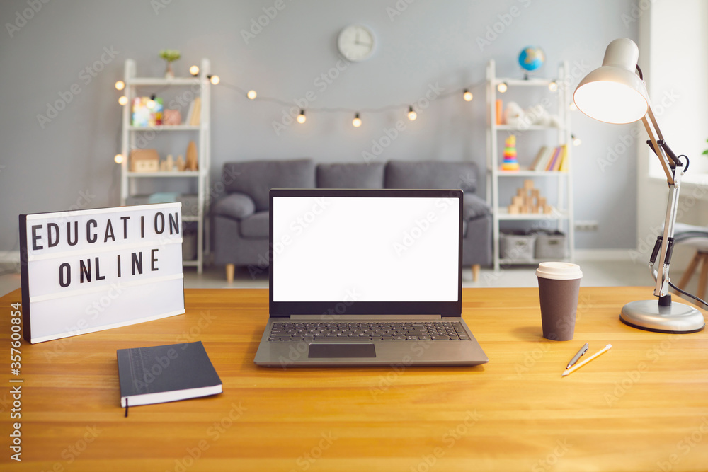 Online education sign and laptop computer with empty screen standing on wooden table in living room, mockup for design Online education sign and laptop computer with empty screen standing on wooden table in living room, mockup for design