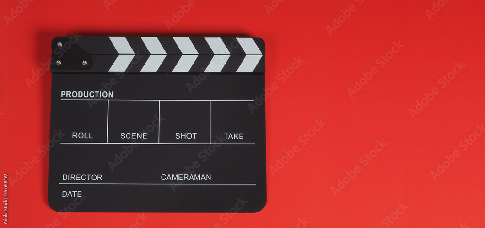 Clapper board or clapperboard or movie slate .It is use in video production ,film, cinema industry on red background.