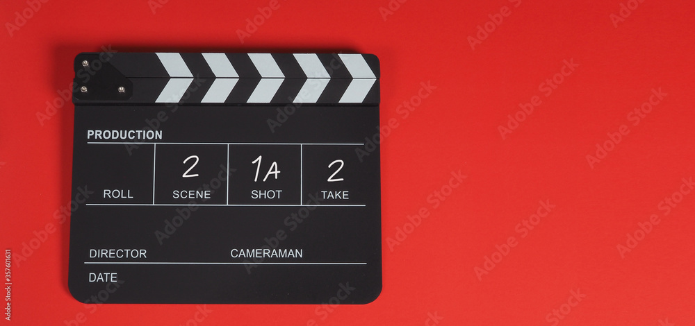 Clapperboard or movie slate. It is used in video production, film, cinema industry on a red background.