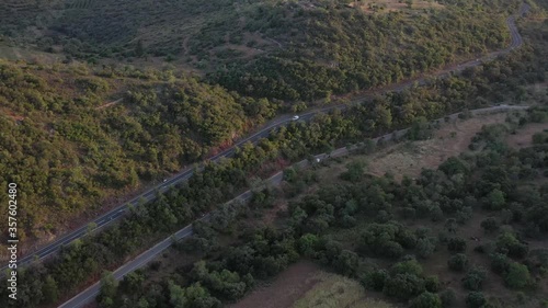 Following white car with drone. Aerial view over natural reservoir in Algarve, Portugal. Road and nature. Sunset landscape.