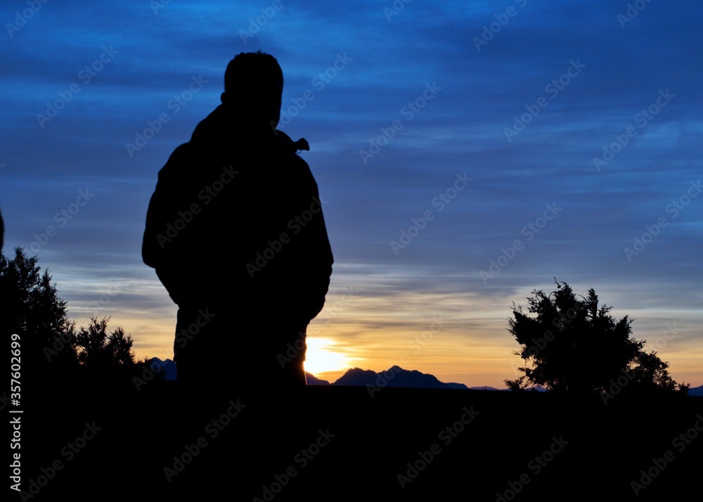 silhouette of a man on the top of mountain