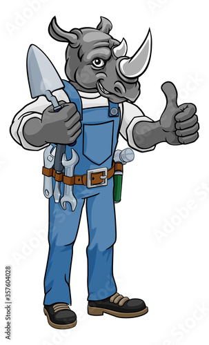 A rhino bricklayer builder construction worker mascot cartoon character holding a trowel tool giving a thumbs up